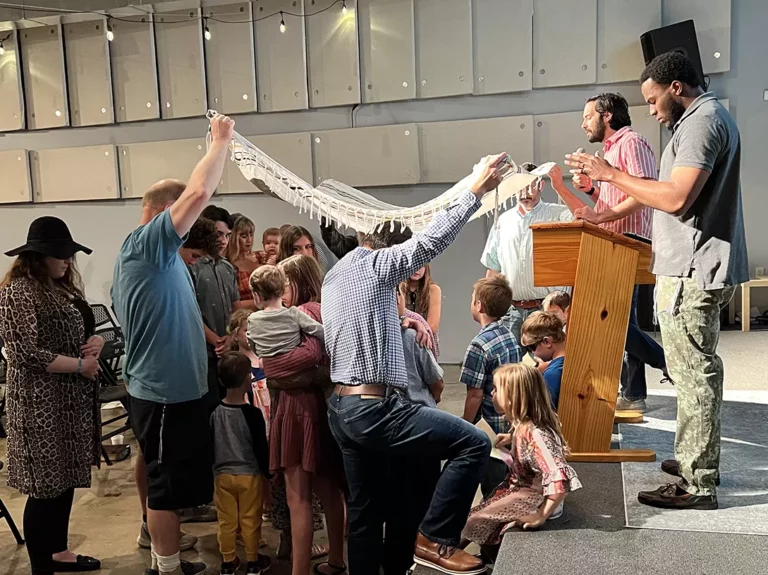 photo of pastor saying a blessing over children during a church service